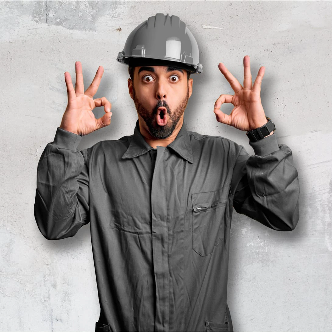 Person in Bauarbeiter*in-Kleidung zeigt ein Ok Symbol mit den Fingern 