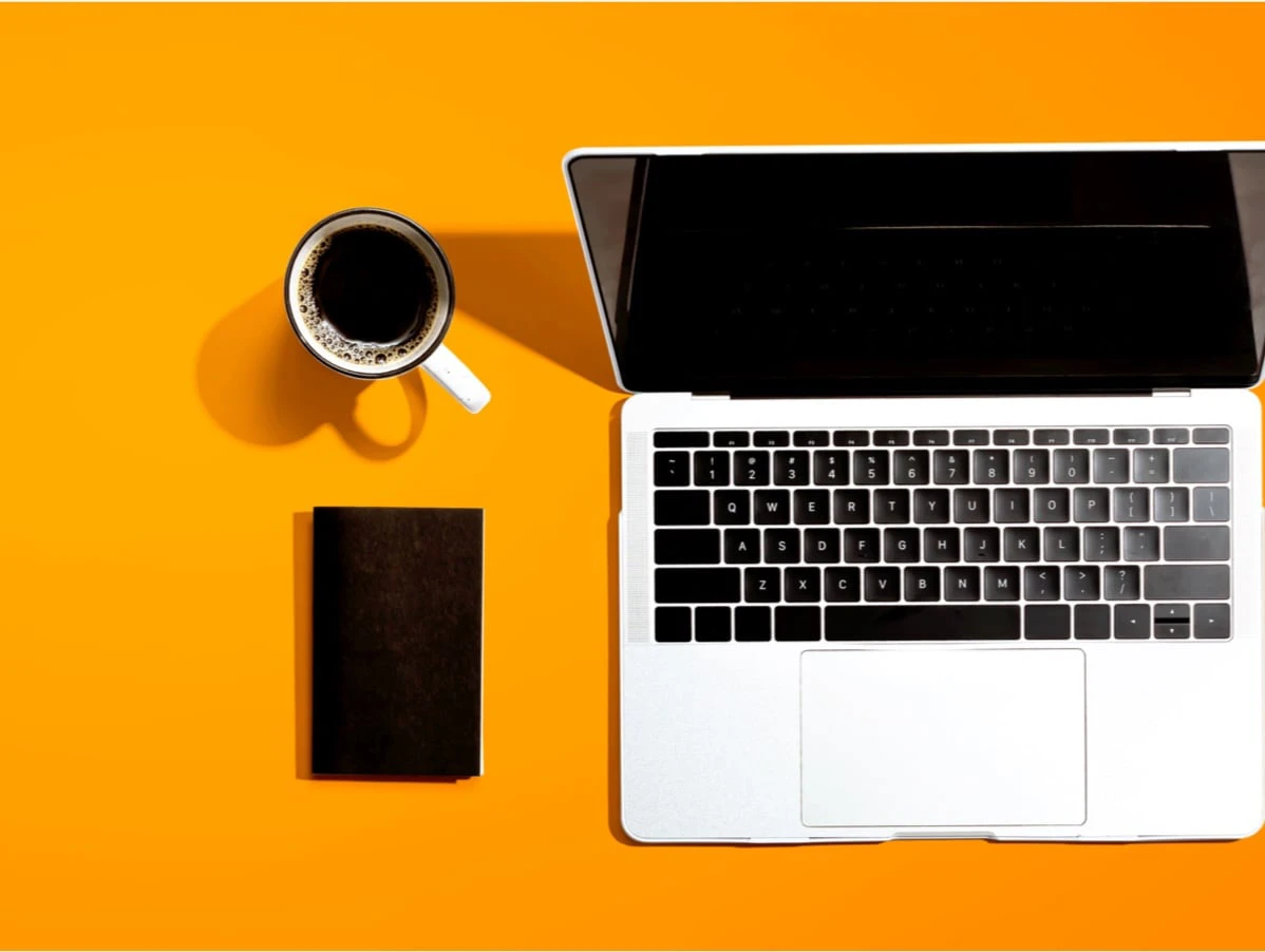 Laptop, Handy und Kaffee auf einem farbigen Hintergrund