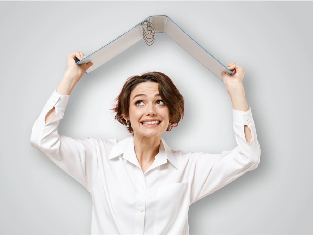 Person hält sich einen leeren Dokumenten-Ordner über den Kopf